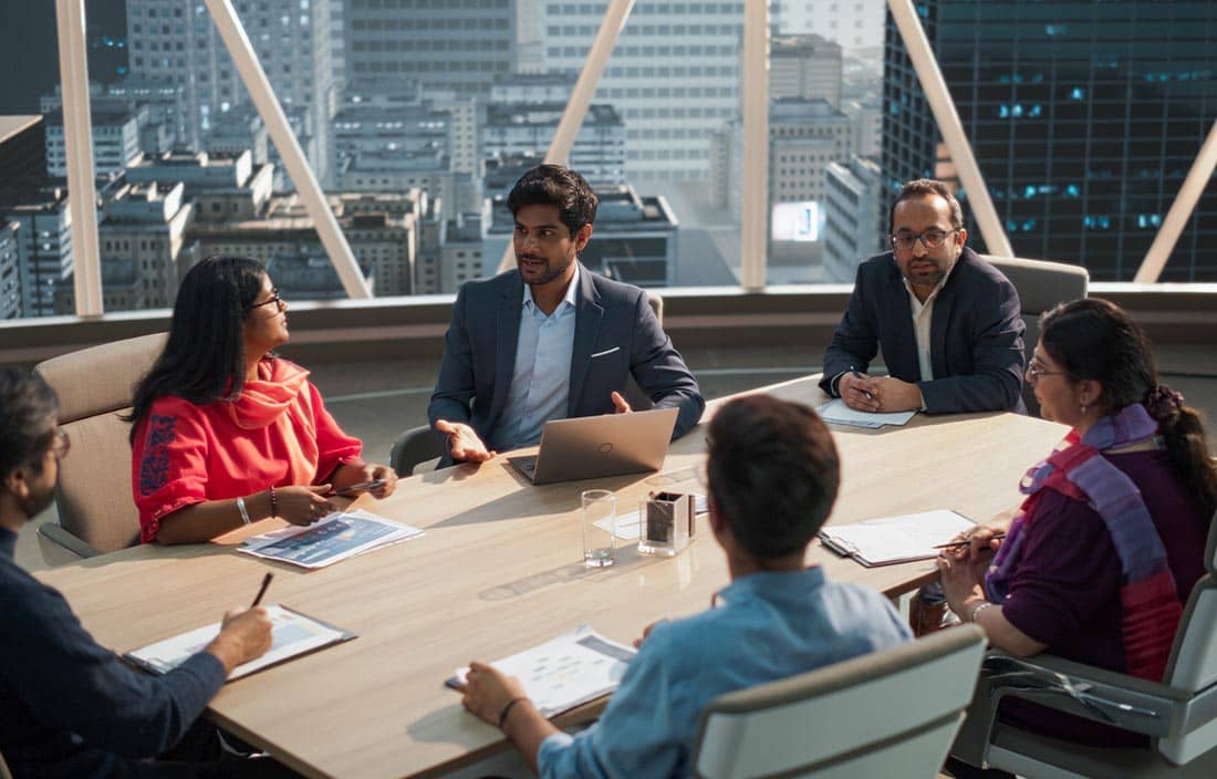 Group of people taking in an office meeting room.