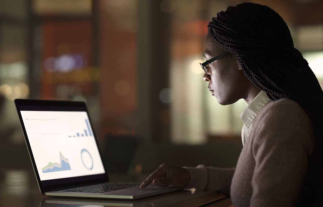 Woman sitting looking at data on computer
