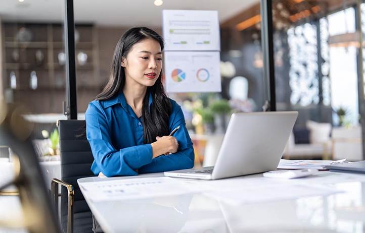 Woman sitting down looking at a laptop screen.