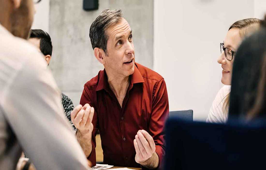 Man talking to people at table