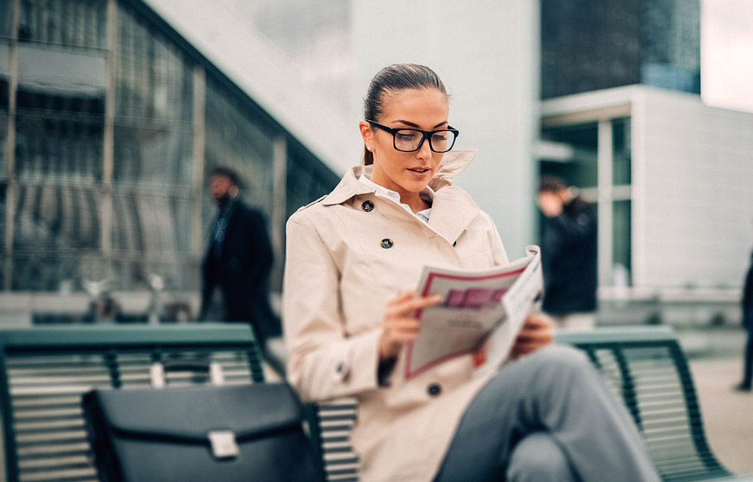 Woman reading newspaper.