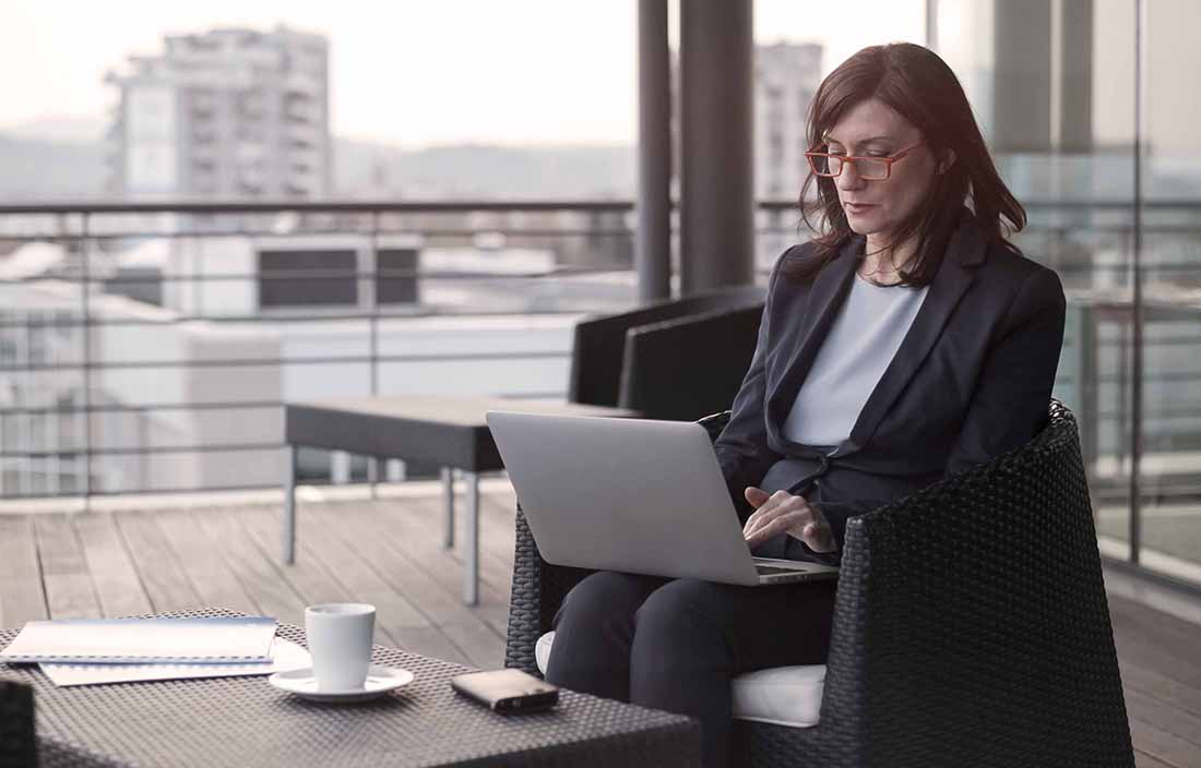 Middle-aged businesswoman using her laptop computer in an outdoor area.