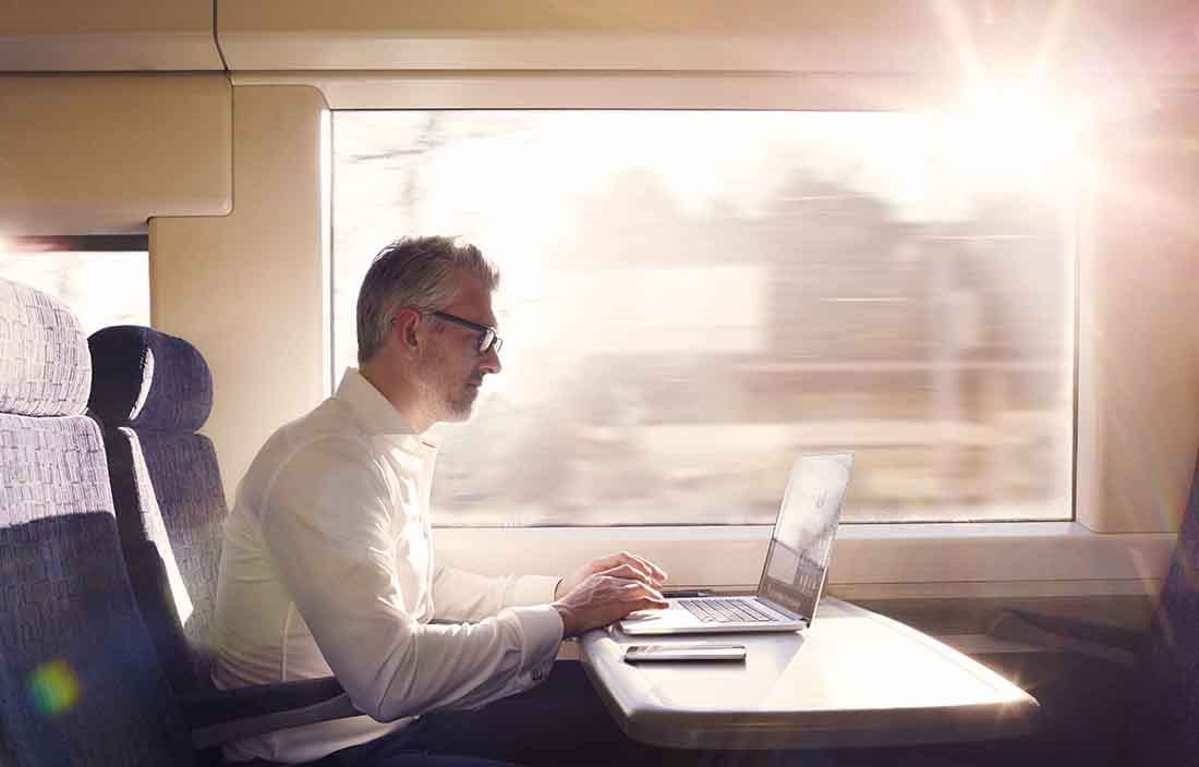 Businessman working on his laptop computer while on a train.