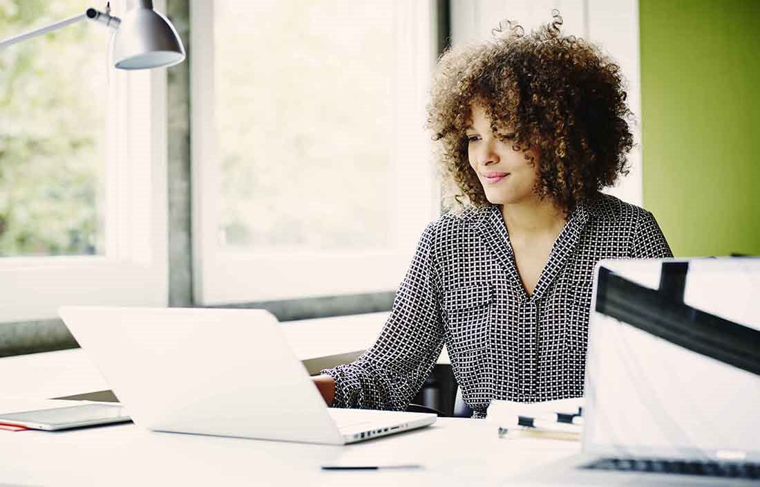 Businesswoman in the office using her laptop computer on a modern desk.