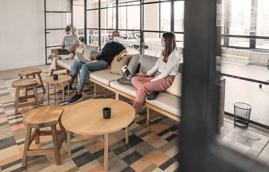 A group of working professionals in a waiting area having coffee.