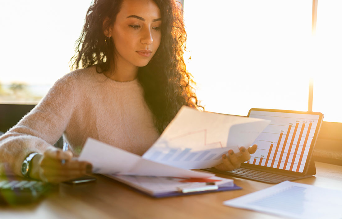 Businesswoman reviewing notes on her desk. 