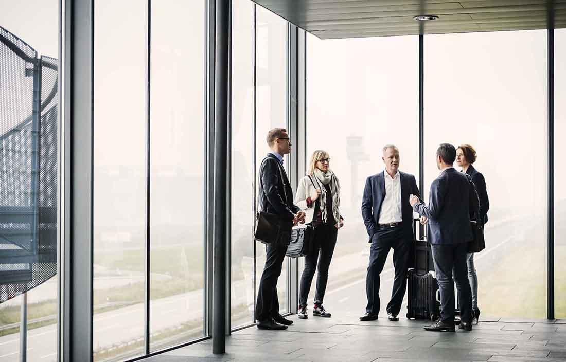 Business professionals standing close to each other talking.