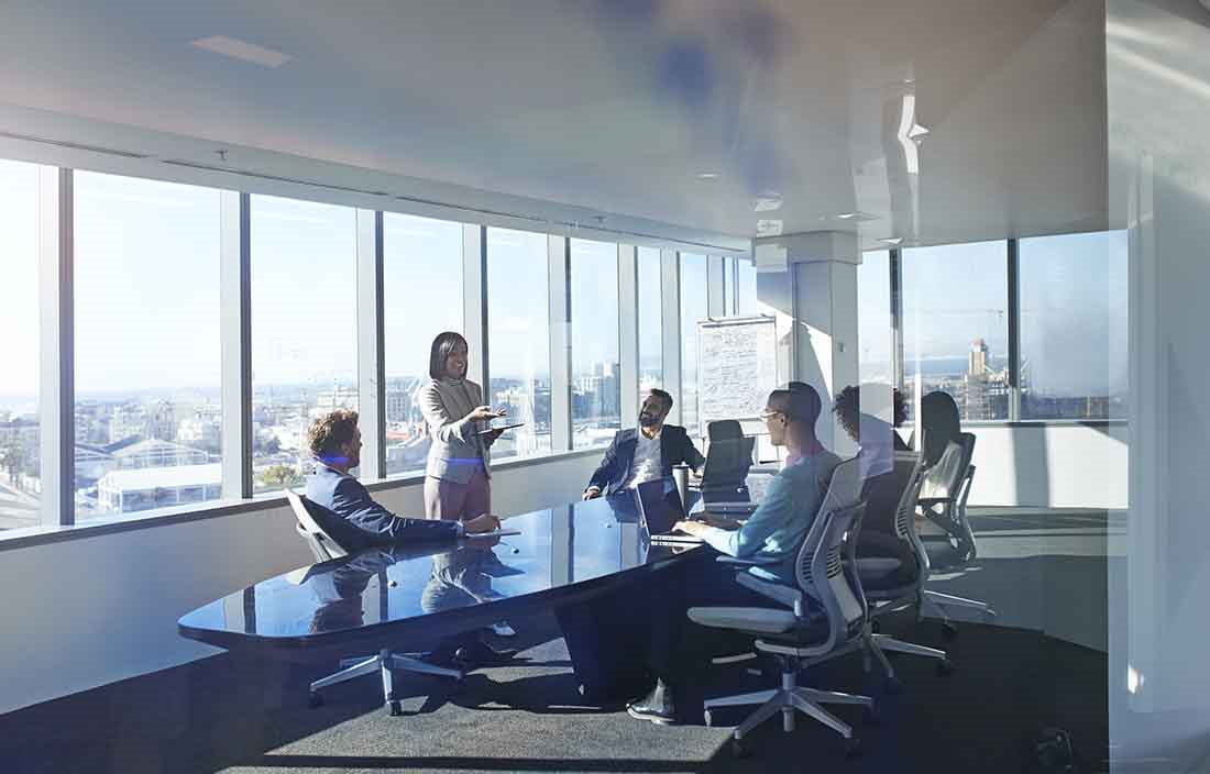 Board/conference room filled with business professionals having a meeting.