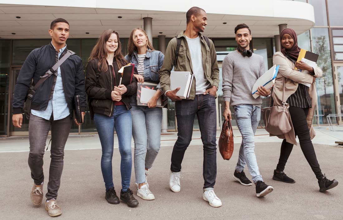 Highschool students walking outside of a school.