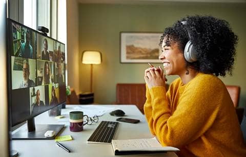 Business professional wearing headphones listening to a webinar