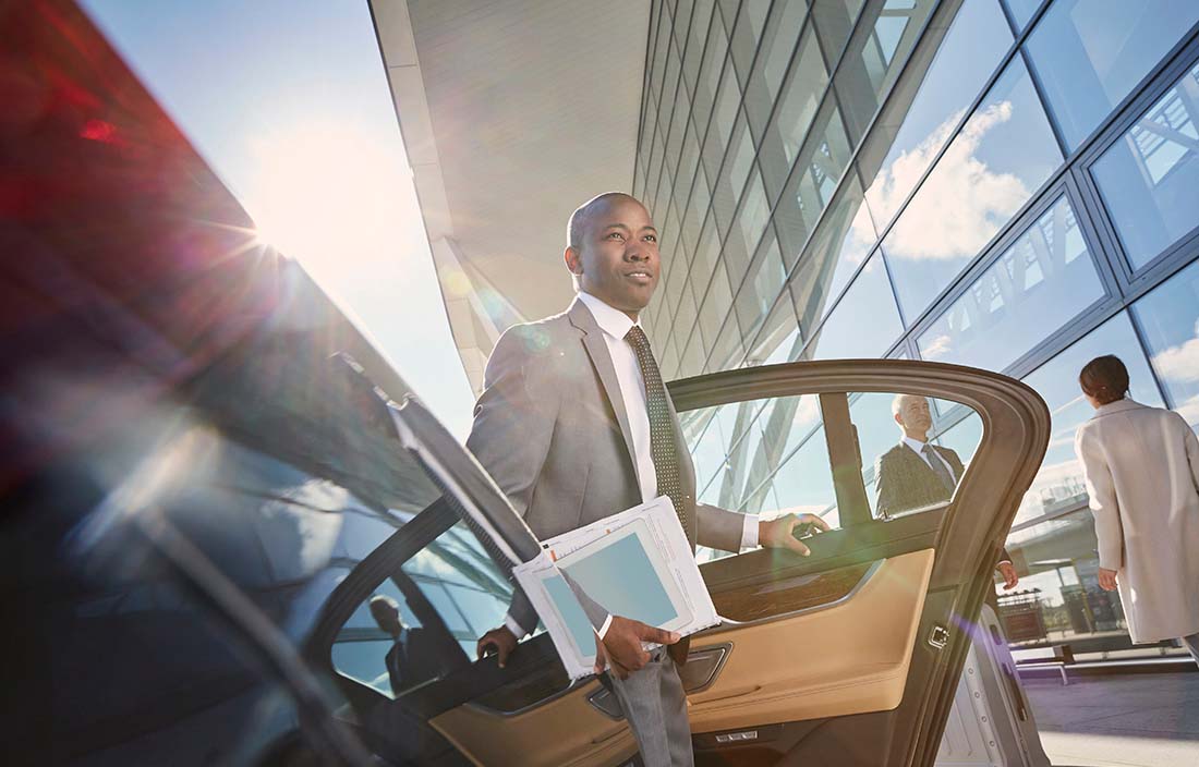 Man in business suit exiting a futuristic car. 
